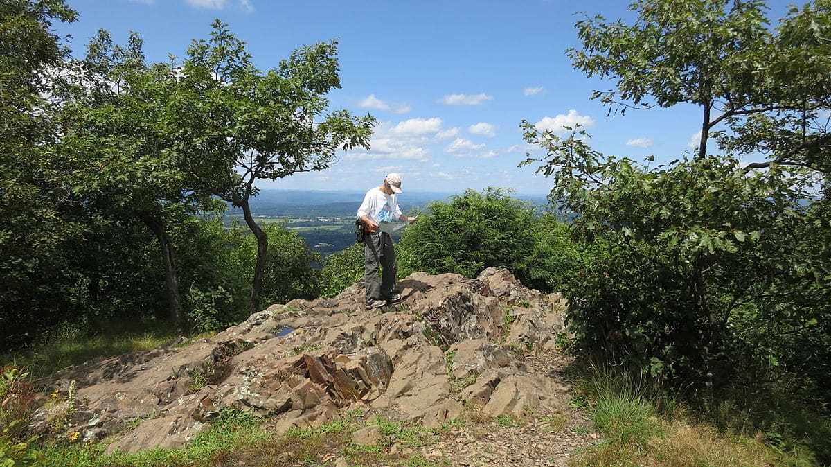 A hiker checks his map at an overlook