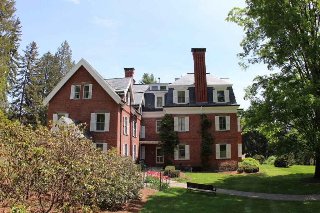 A red brick house with three stories and a chimmney