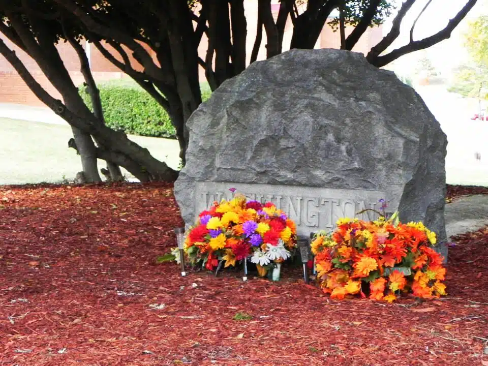 Booker T. Washington's grave stone with flowers at the base.