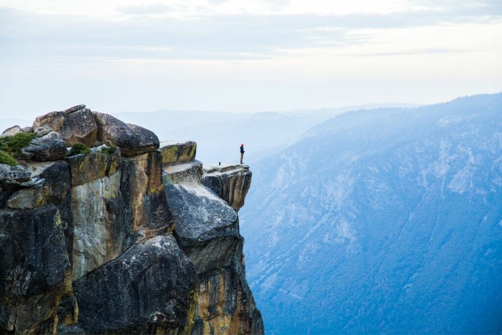 A man enjoying the a view while standing on a rock outcropping