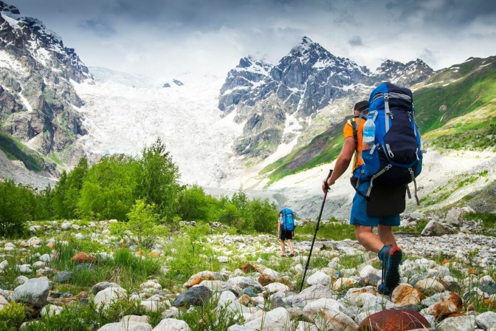 Two backpackers hiking up to a mountain glaicer.  