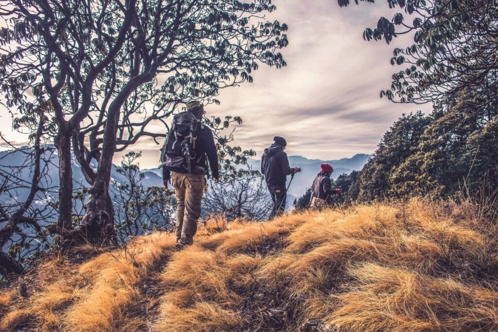 3 people in jackets hiking in the dusty mountains.  