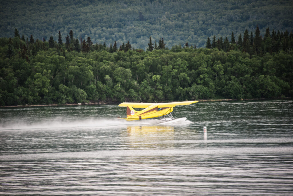 A yellow float plane preparing for take-off at Brooks Camp