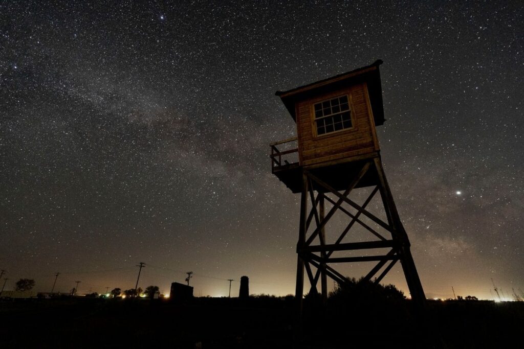 A starry sky and a guard tower in the forground 