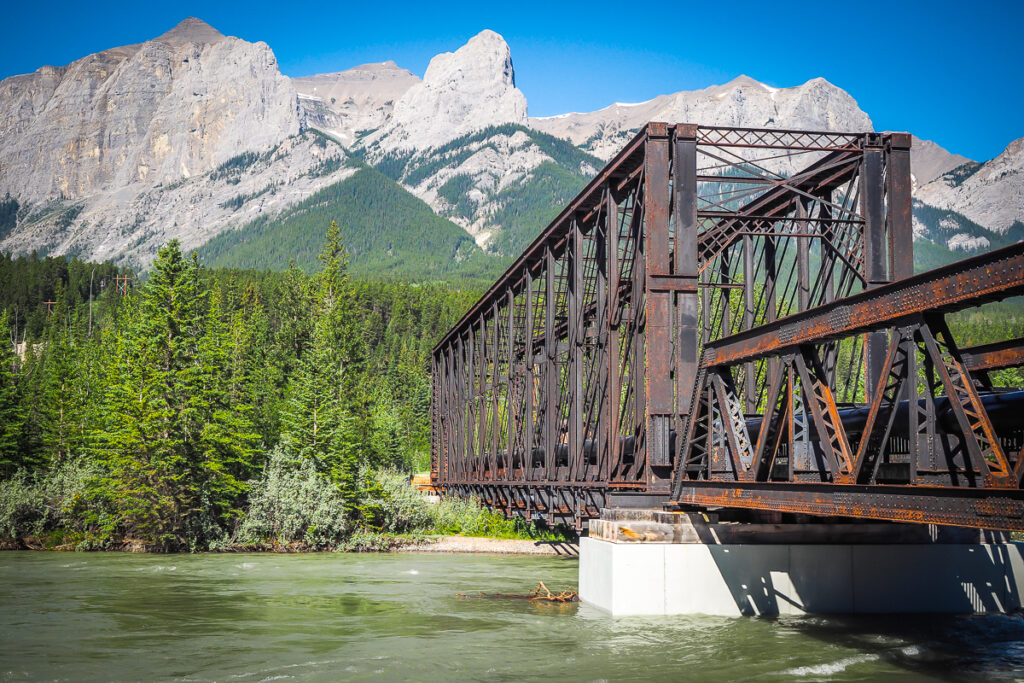 A truss bridge with mountains over the background