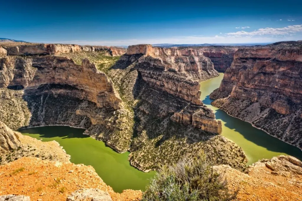 A large canyon with a lake at the bottom.