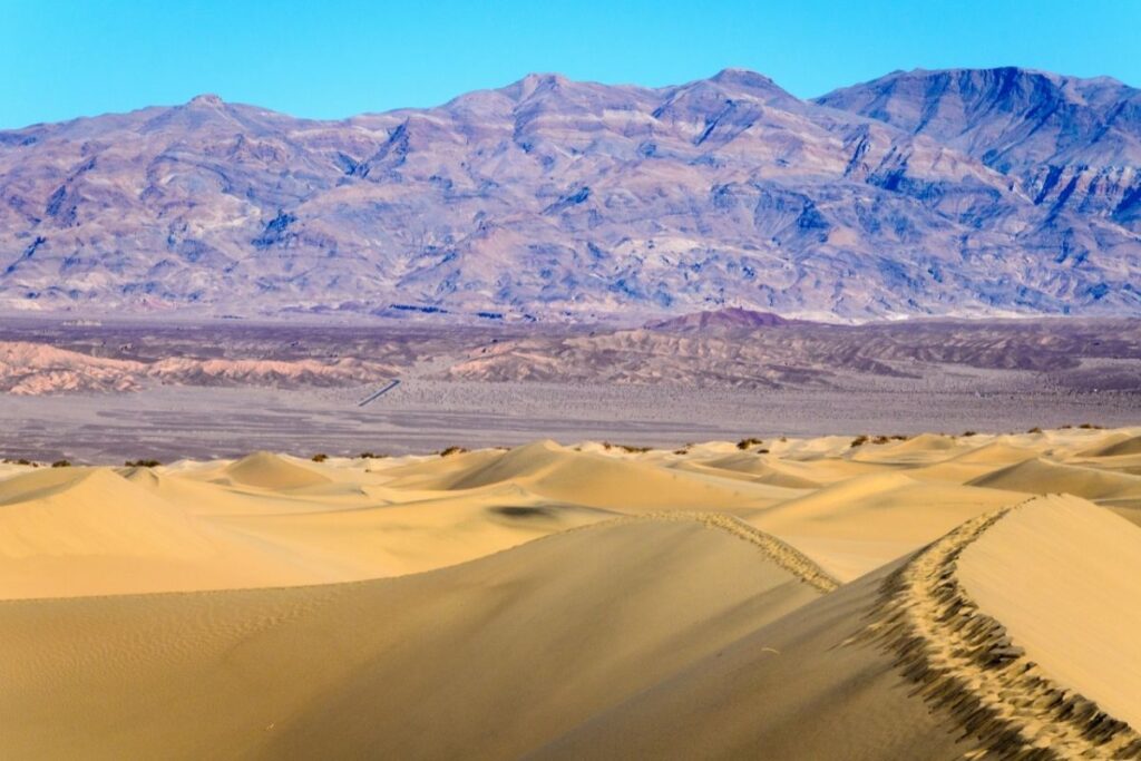 Sand dunes over looking a desert valley and mountains