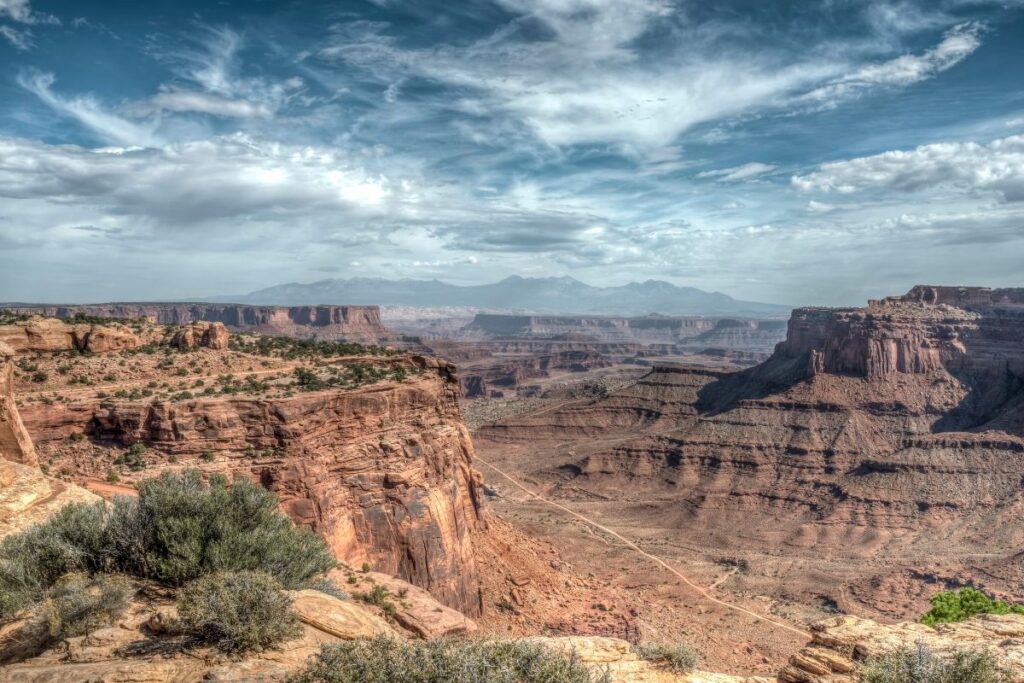 A view point overlooking a dirt road and a deep canyon