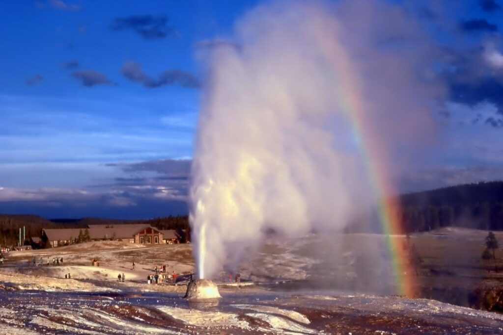 Beehive geyser erupts and creates a rainbow.