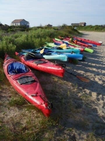 Kayaks sitting the dunes awaiting to be used.