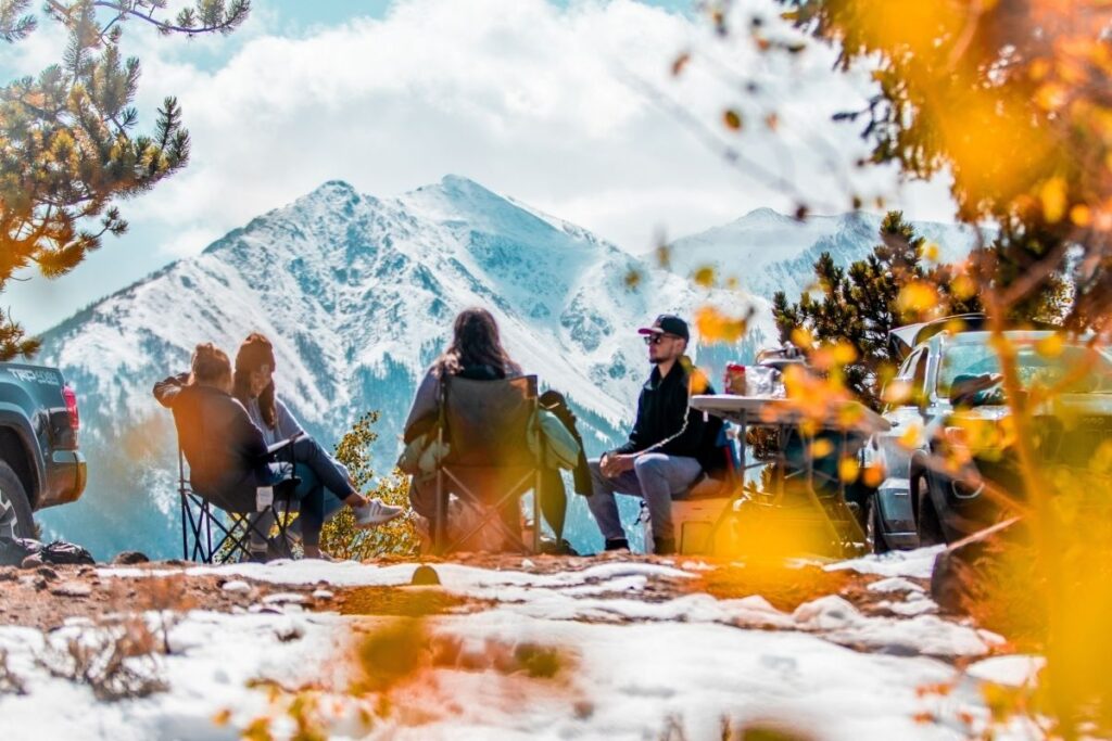 Four people sitting around the campfire in the mountains.