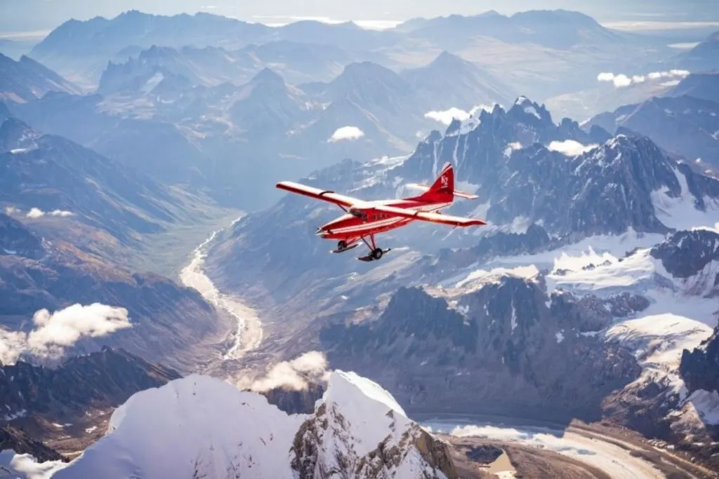 a red plane flying in Alaska