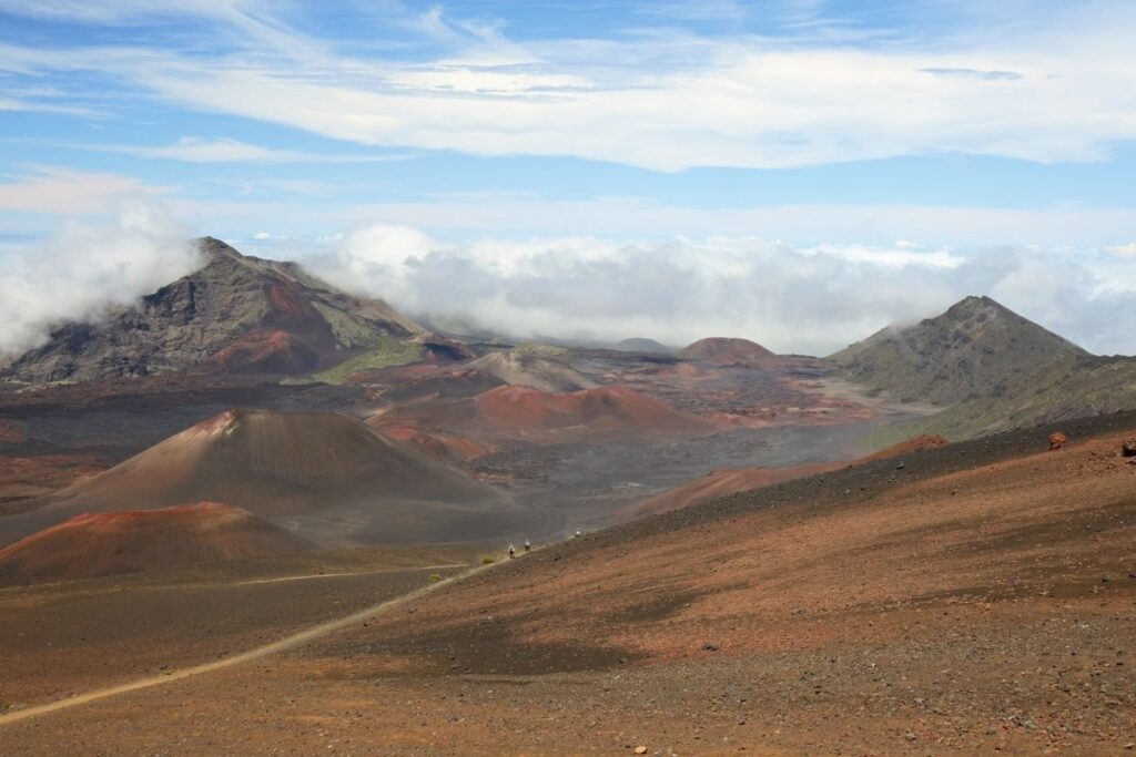 a baren volcanic landscape with a trail running through it.