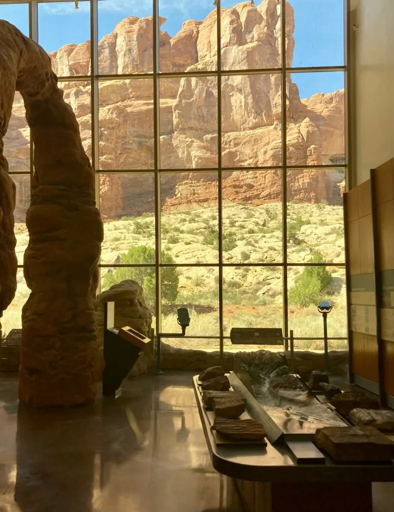 A view out of a window looking out to a rock wall.