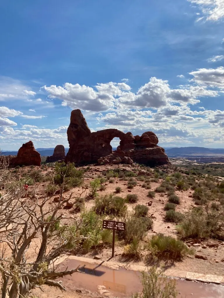 A rock arch in the middle of a small rock wall.  