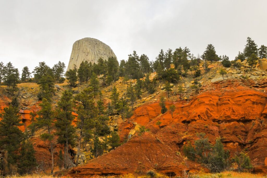 Devils Tower peaks over a hill