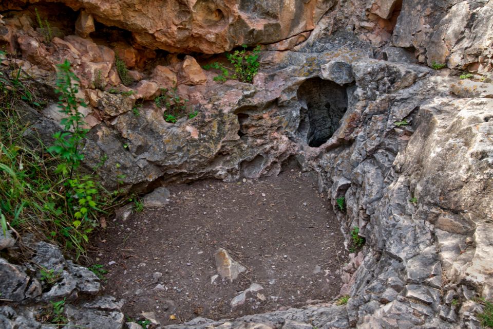 a rocky area with a small cave entrance