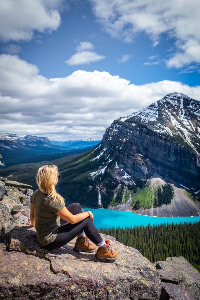 A hiker seated on a rocky outcrop overlooking Peyto Lake in Banff National Park, contemplating the serene beauty, perfect for 'Hiking Tips for Beginners' on choosing picturesque trails.