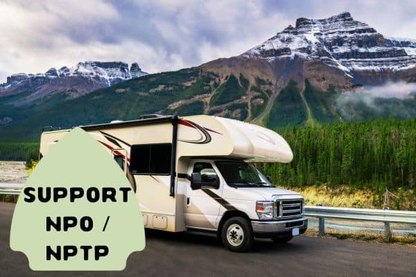 The image features a motorhome parked on a roadside, with a majestic mountain landscape in the background. The RV is positioned in a stunning natural setting, highlighting the freedom and appeal of road-trip travel in scenic areas.