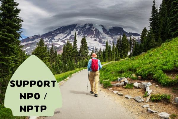 A person hiking on a trail surrounded by lush greenery with a mountain in the background, under a cloudy sky, with text "Support NPO / NPTP" in a green badge on the left side.