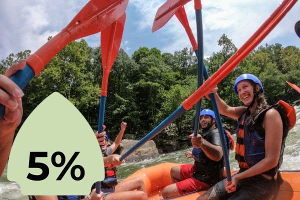 A group of people rafting, raising their paddles in celebration while navigating a river. A green icon with "5%" is superimposed on the left side.