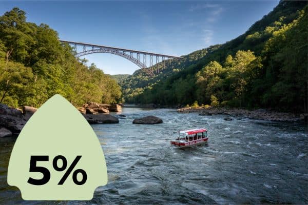 A scenic view of a river with a boat navigating through the water and a bridge in the background. A green icon with "5%" is superimposed on the left side.