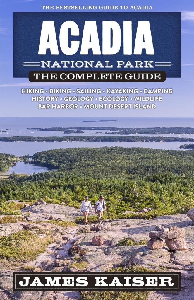 Book cover of "Acadia National Park. The Complete Guide" by James Kaiser, featuring the words "The Bestselling Guide to Acadia" and topics including "Hiking. Biking. Sailing. Kayaking. Camping. History. Geology. Ecology. Wildlife. Bar Harbor. Mount Desert Island." Two hikers climb a rocky trail above dense green forests, blue waterways, and distant islands.